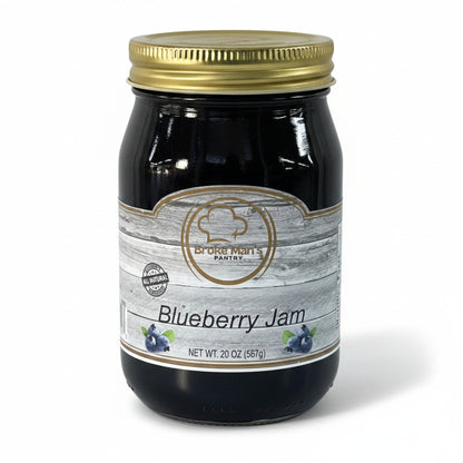 Broke Man's Pantry all-natural blueberry jam in a 20oz glass jar with a gold lid and rustic wood-grain label.