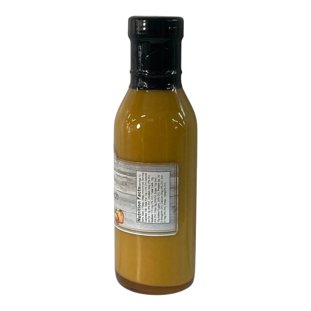 Broke Man's Pantry Southern Peach Dressing in a glass bottle with a black cap and nutrition label on a black background
