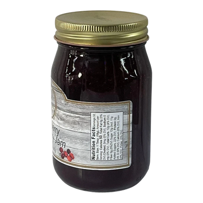 Broke Man's Pantry Strawberry Cranberry Jam in a glass jar with a gold lid and nutrition label on a black background.